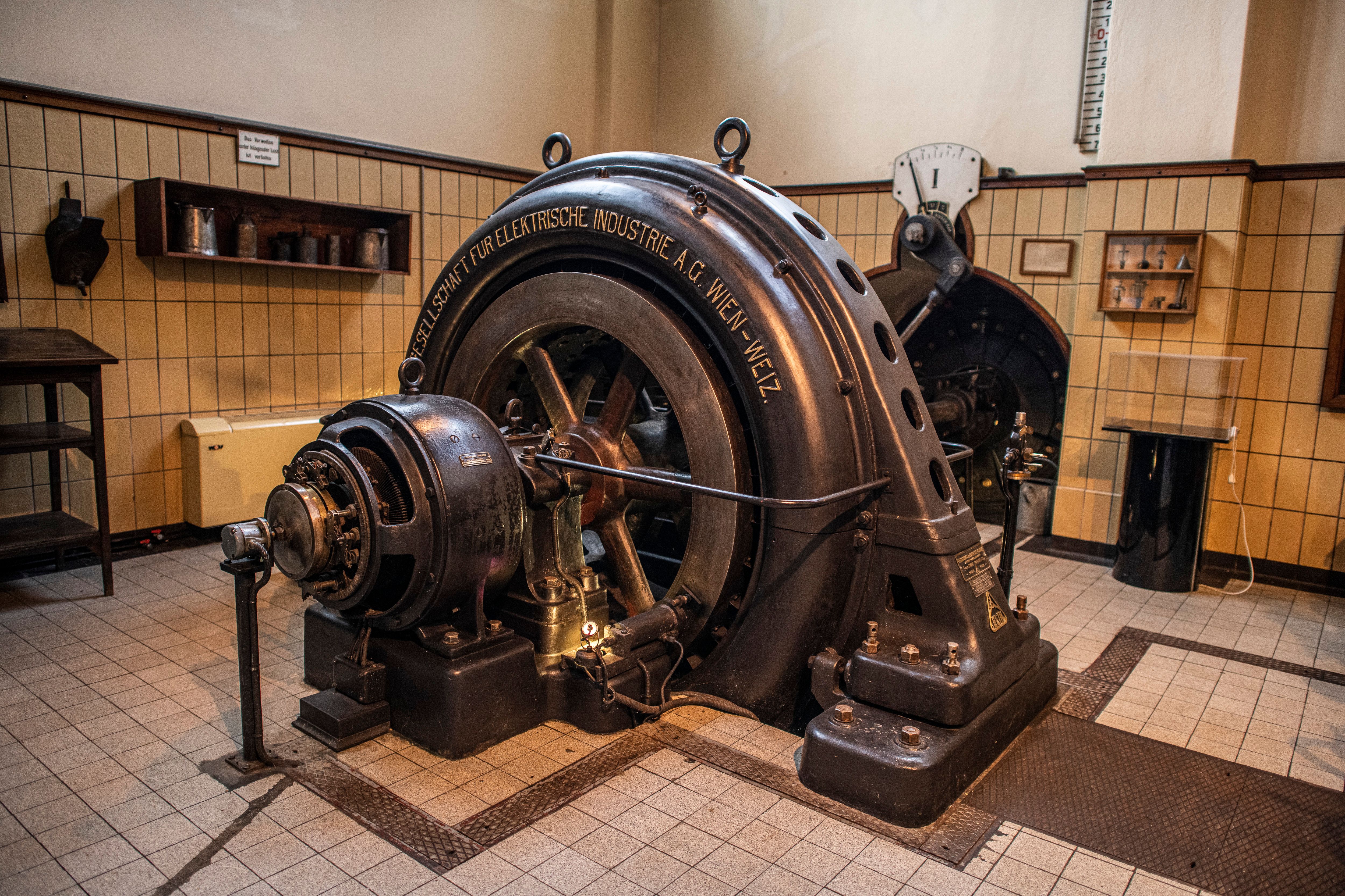 Historischer Generator im Schaukraftwerk Schwellöd in einer original erhaltenen Maschinenhalle mit Industriearchitektur und technischen Details.